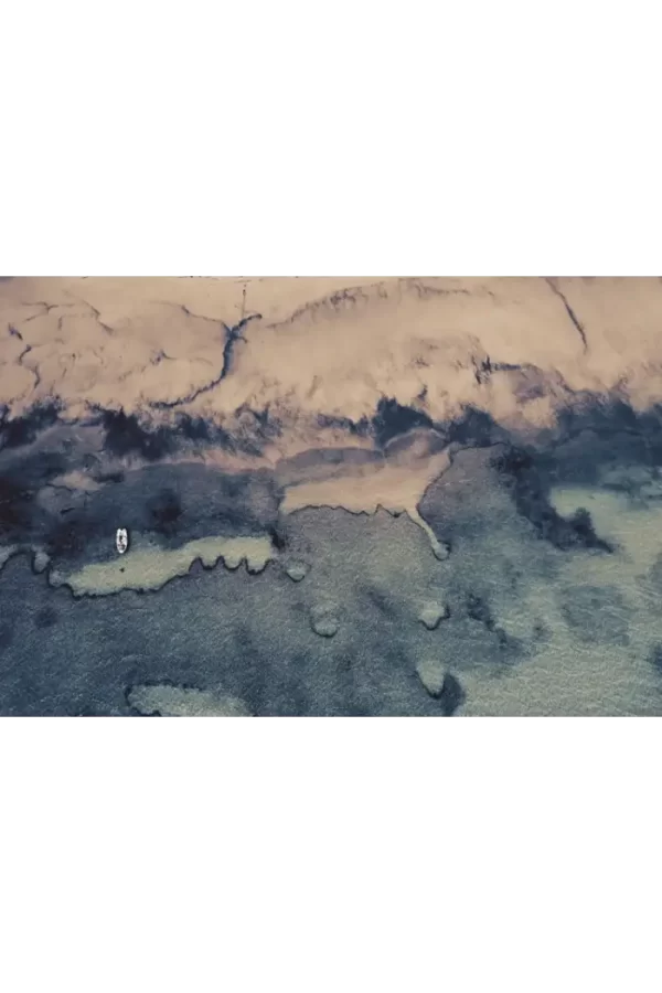 Koloritna morska obala sa čamcem i mrežom za odbojku.