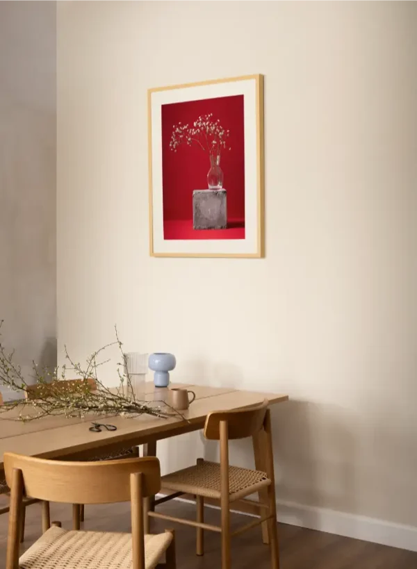 Fotografija sitnog bijelog cvijeća u staklenoj vazi na crvenoj pozadini - slika za zid medium