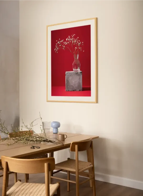 Fotografija sitnog bijelog cvijeća u staklenoj vazi na crvenoj pozadini - slika za zid large